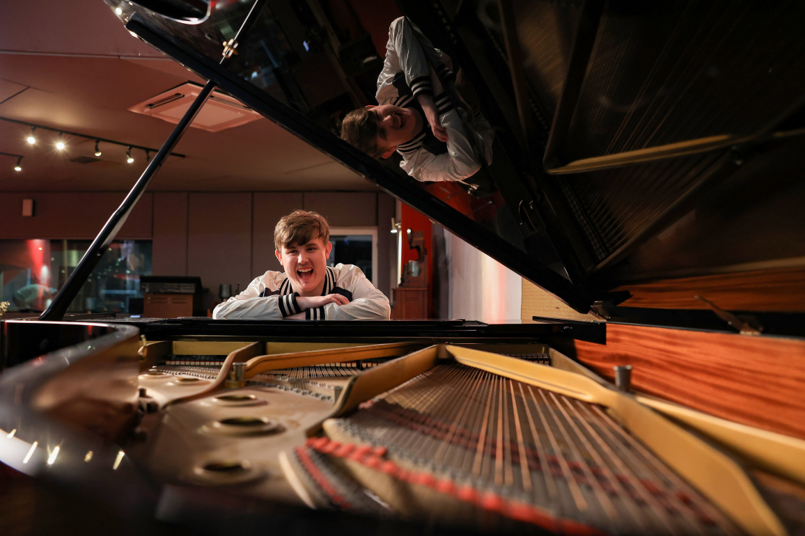 Young learner sitting at a grand piano