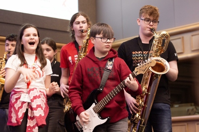 1 singer, 1 guitarist and 2 saxophone players perform on stage