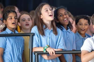 Group of young singers standing and singing together.